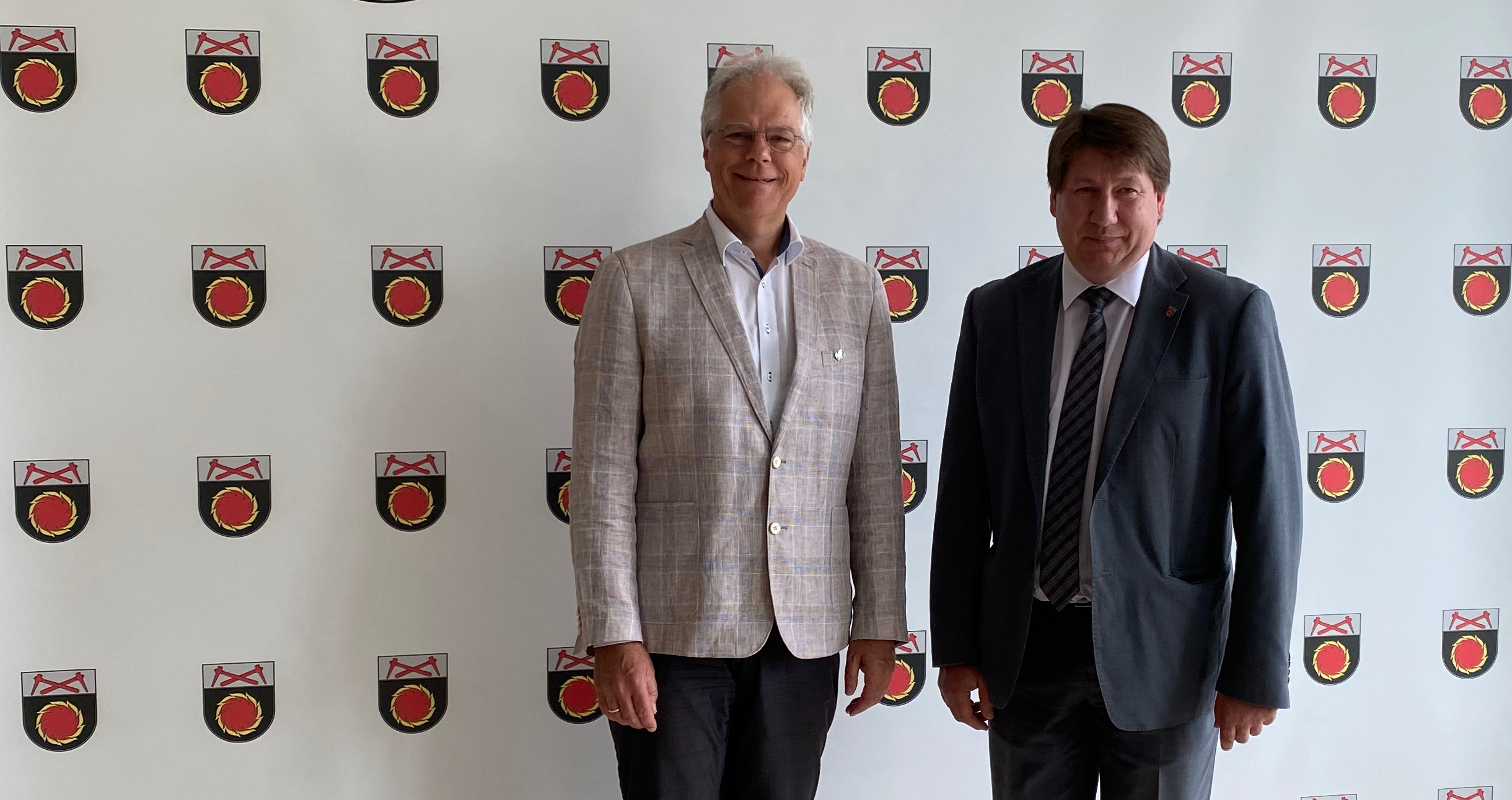 Besuch beim Bürgermeister von Naujoji Akmenė, Vitalijus Mitrofanovas. Der rote Flammenkreis im Wappen symbolisiert den Ursprung der Stadt, die Herstellung von Zement. Die Spitzhacken oben stehen für den historischen Bergbau in der Region.
